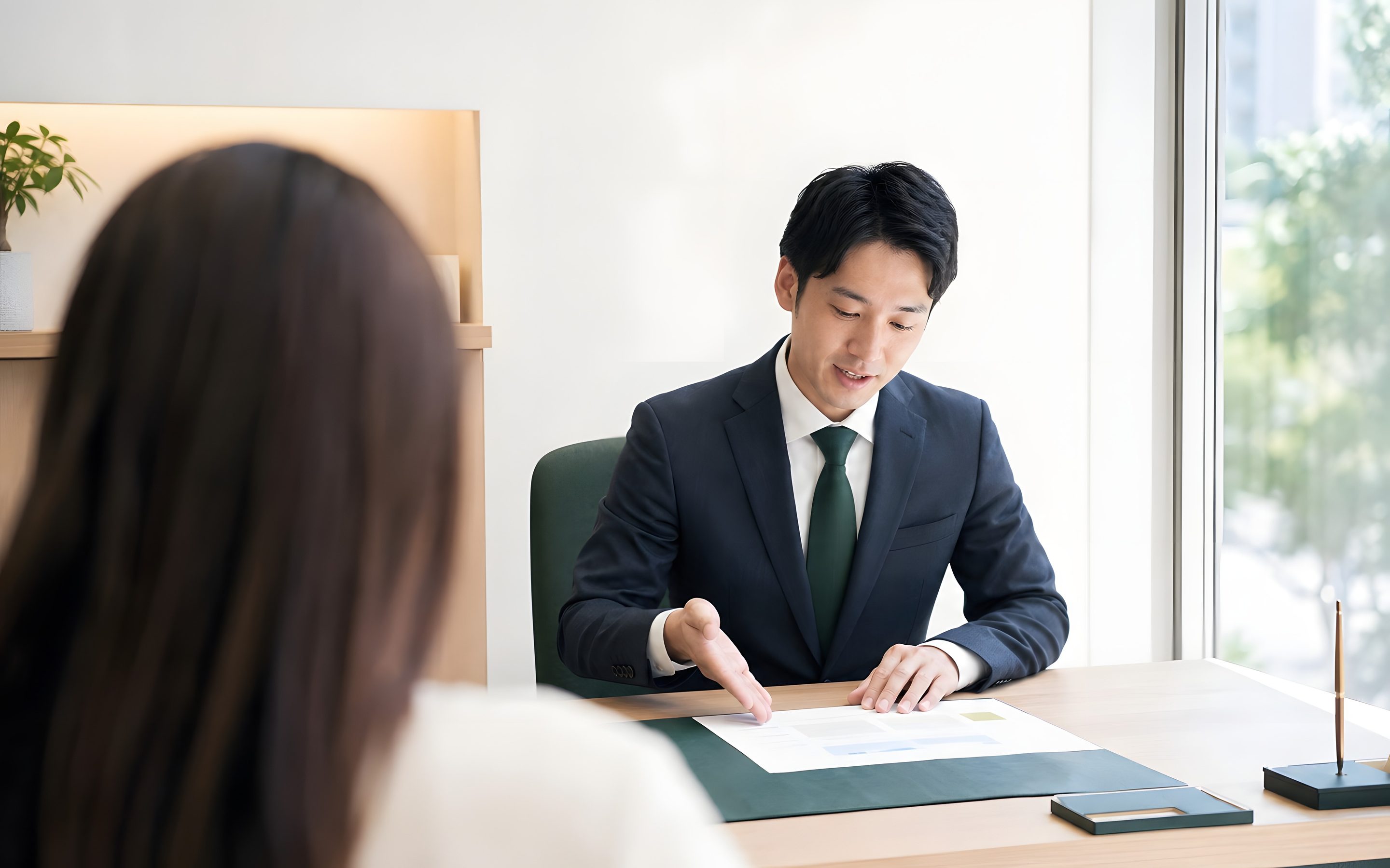 机をはさんで、申請書類を前に打ち合わせをしている様子