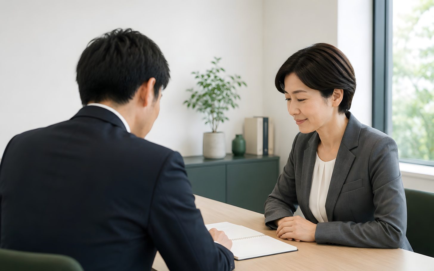 机をはさんで、書類を見ながら話している様子